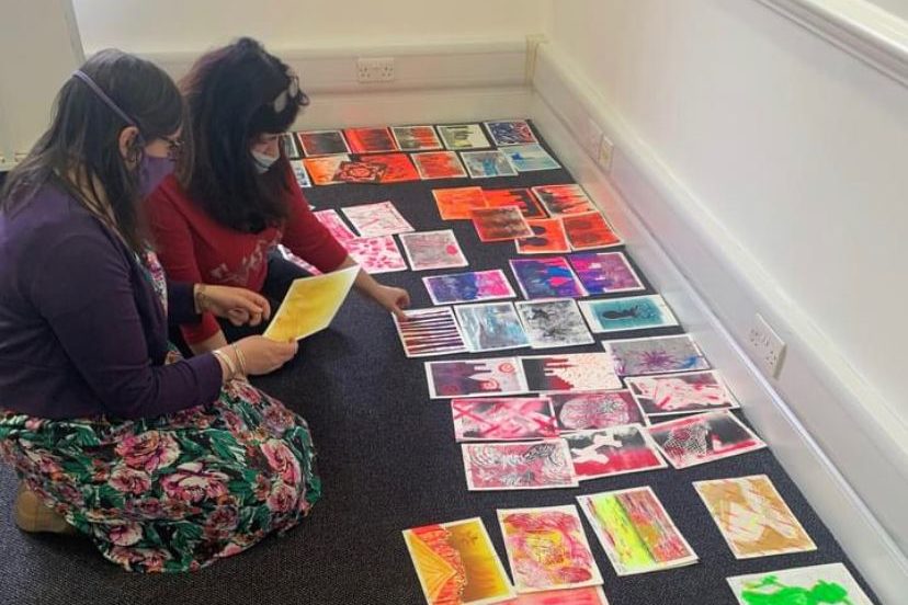 Sudi sorting a collection of art prints for an exhibition
